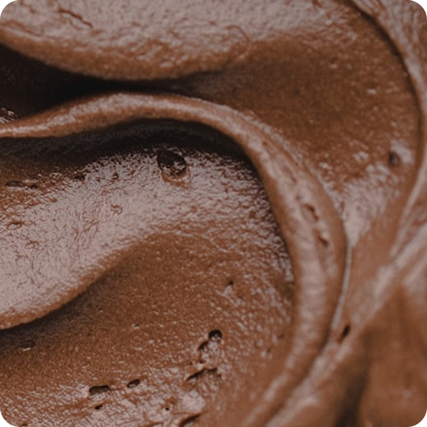 Close-up of smooth, creamy chocolate spread with glossy texture and swirls.
